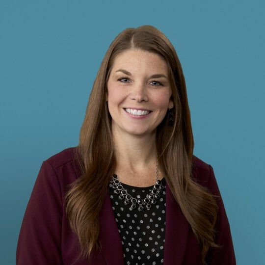Professional headshot of Jessica C. Emmons, APRN-CNP in burgundy blazer smiling