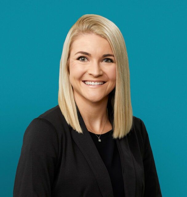Professional headshot of Jessica Stull, APRN-CNP, smiling in black blazer against teal background