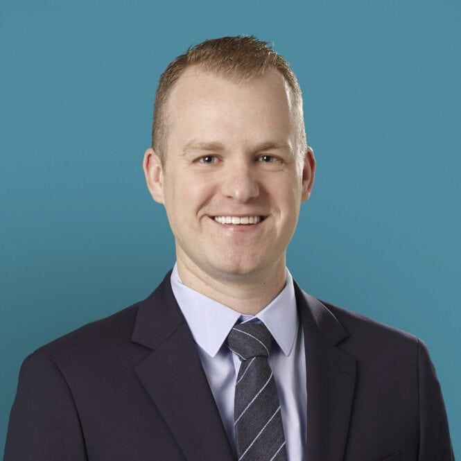 Professional headshot of Justin D. Thomas, DO in dark suit and striped tie