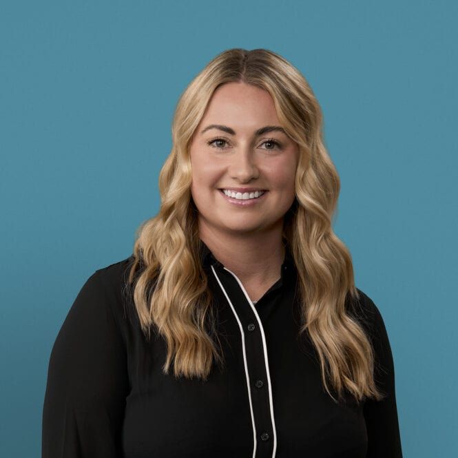Professional headshot of Katlyn Robison, APRN-CNP, smiling in black blouse against blue background