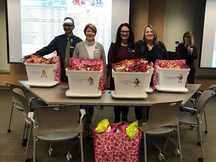Healthcare staff members standing behind table with donation baskets filled with candy and gifts