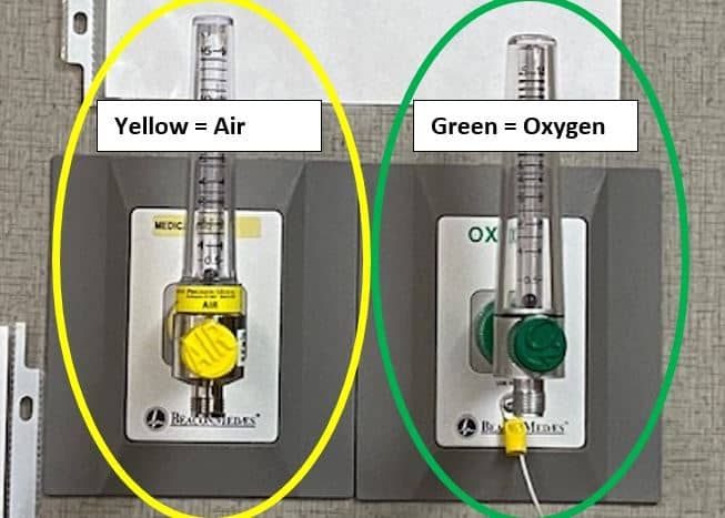 Medical gas outlets showing yellow air valve and green oxygen valve with flow meters.