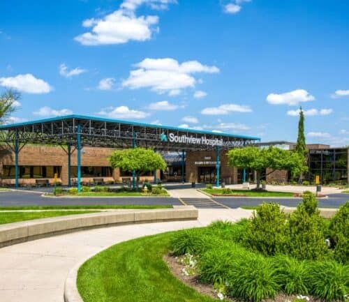 Modern Southview Hospital building with teal canopy and landscaped entrance on sunny day