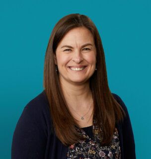 Professional headshot of Vanessa Wehrley, APRN-CNP, smiling in navy cardigan against teal background