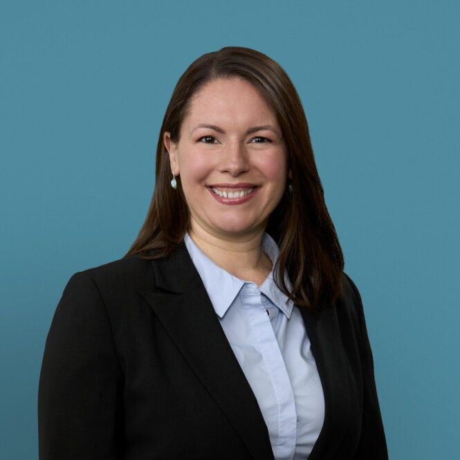 Professional headshot of Virginia Frazier, APRN-CNP in business attire against blue background