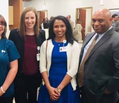 Four healthcare professionals standing together at a networking event wearing name badges