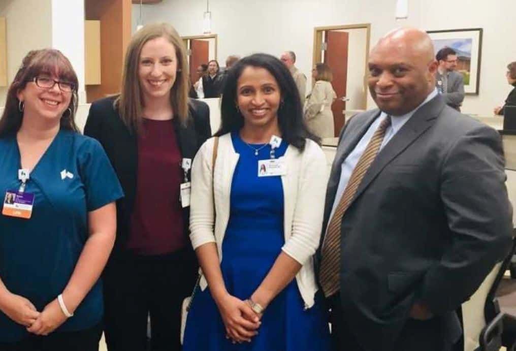 Four healthcare professionals standing together at a networking event wearing name badges