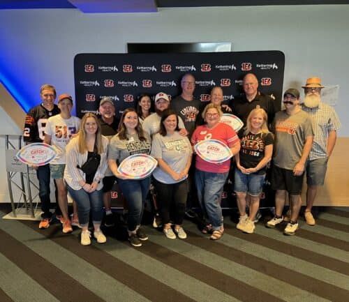 Group of Bengals fans posing with football-shaped awards at Kettering Health event