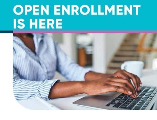 Person typing on laptop with "Open Enrollment is Here" text overlay