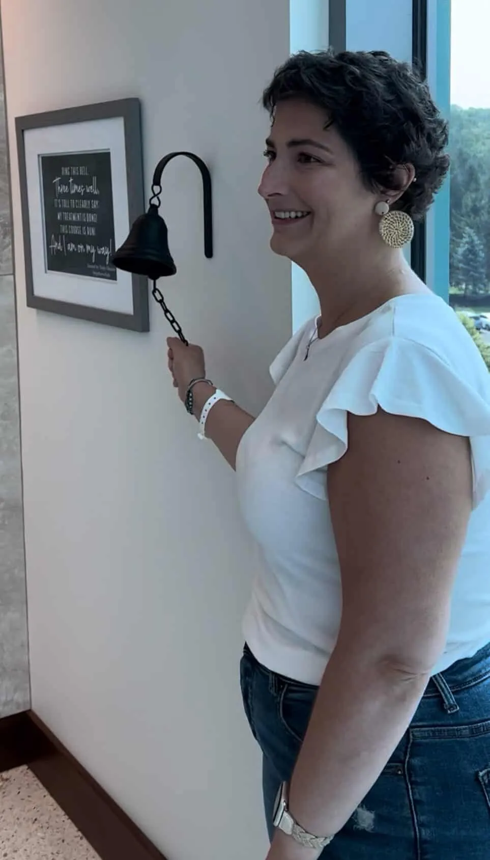 Abby Eller ringing the bell, signaling the completion of her treatment