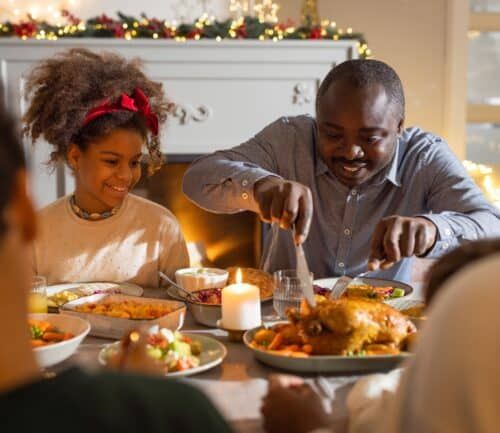 Father and daughter enjoying holiday meal together at decorated dining table