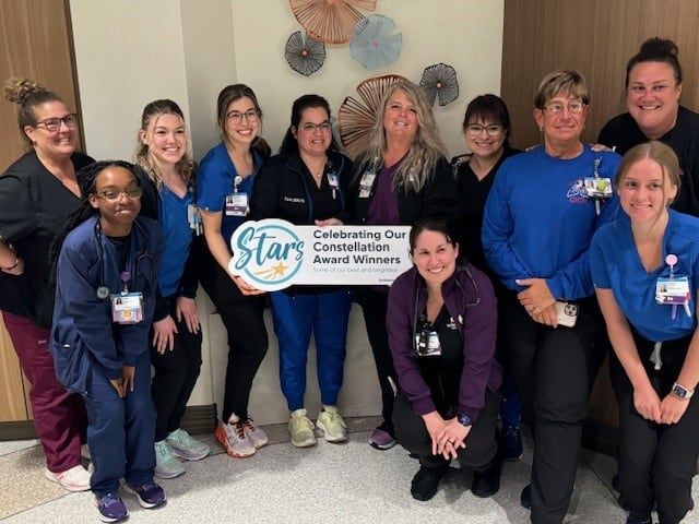 Healthcare team celebrating with Constellation Award Winners banner in hospital setting