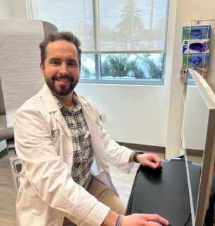 Dr. de la Pena at a computer in an exam room.