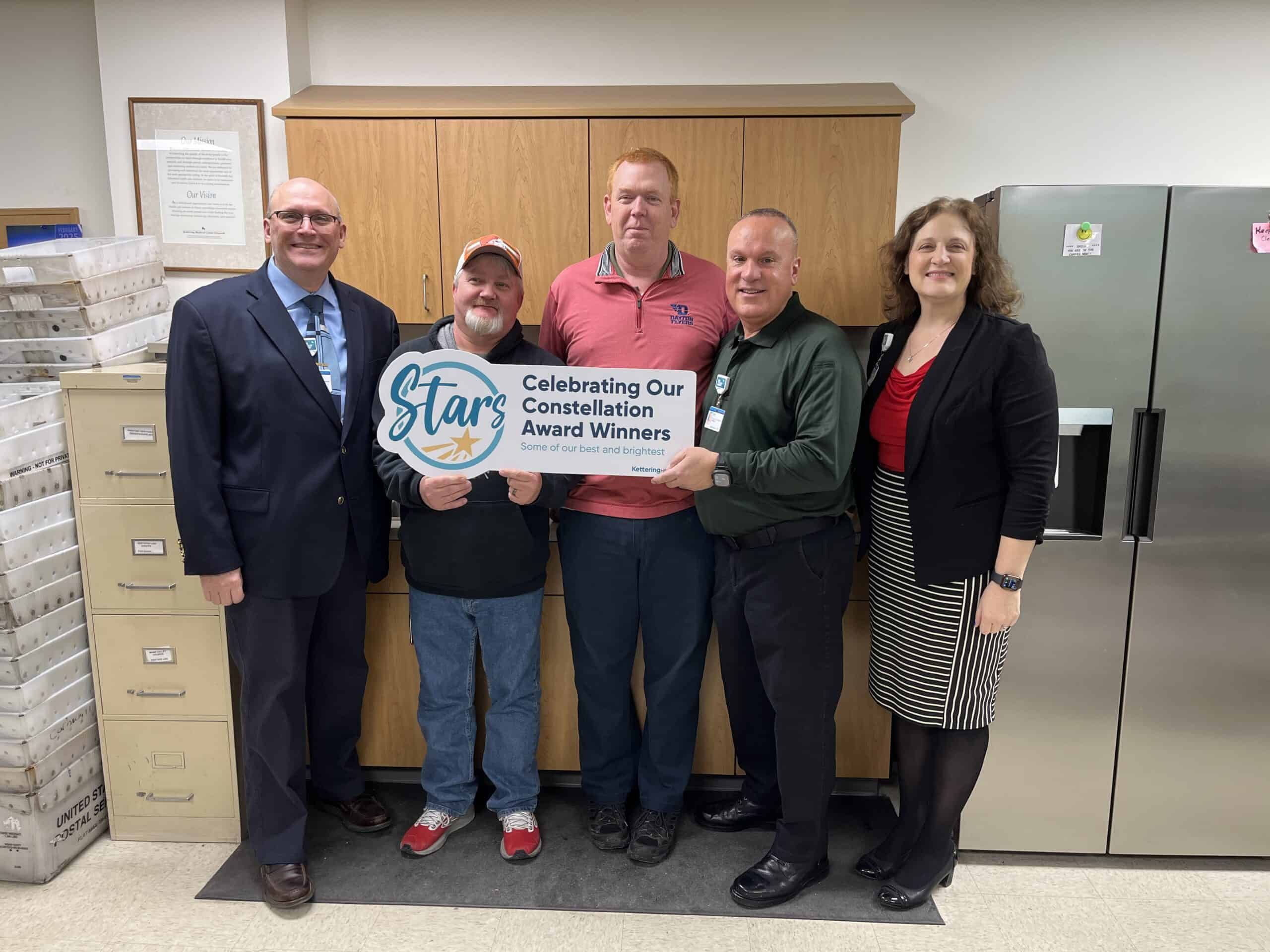 Five employees holding Constellation Award Winners sign celebrating healthcare team recognition
