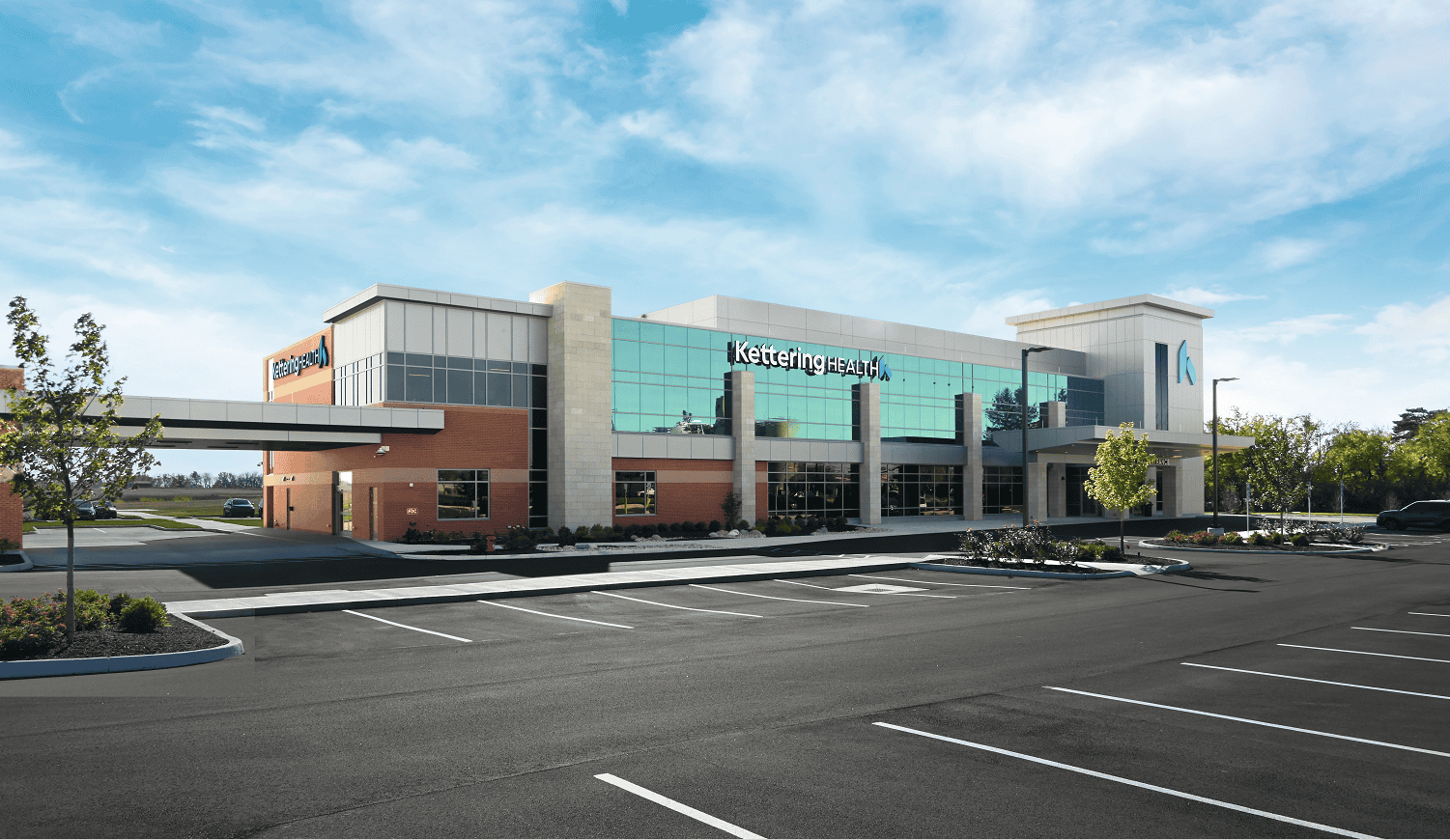 Modern Kettering Health medical facility with glass facade and parking lot in Wilmington