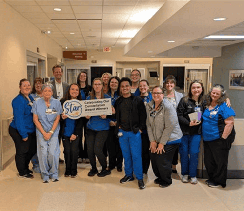 Healthcare team celebrating with Constellation Award Winners banner in hospital lobby