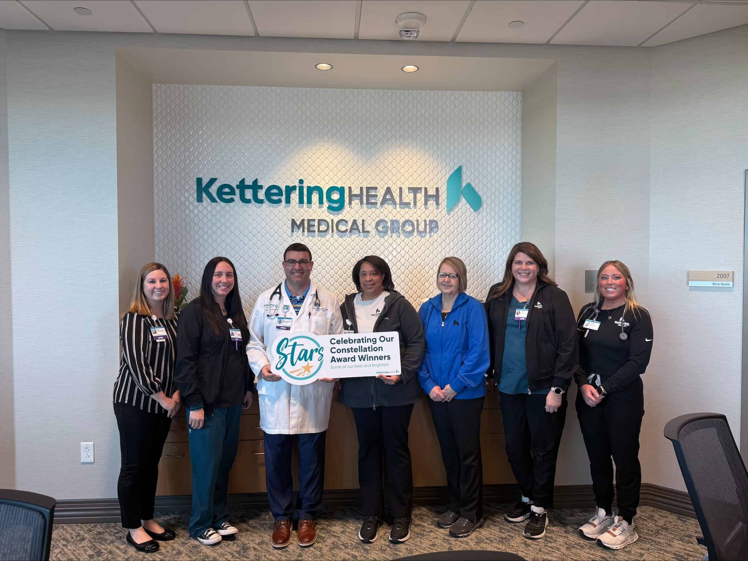 Seven healthcare staff members celebrating Constellation Award winners at Kettering Health Medical Group