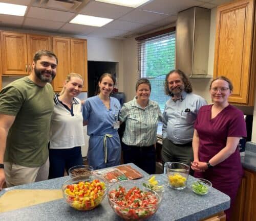 Healthcare team members preparing colorful fresh vegetables and ingredients in kitchen setting