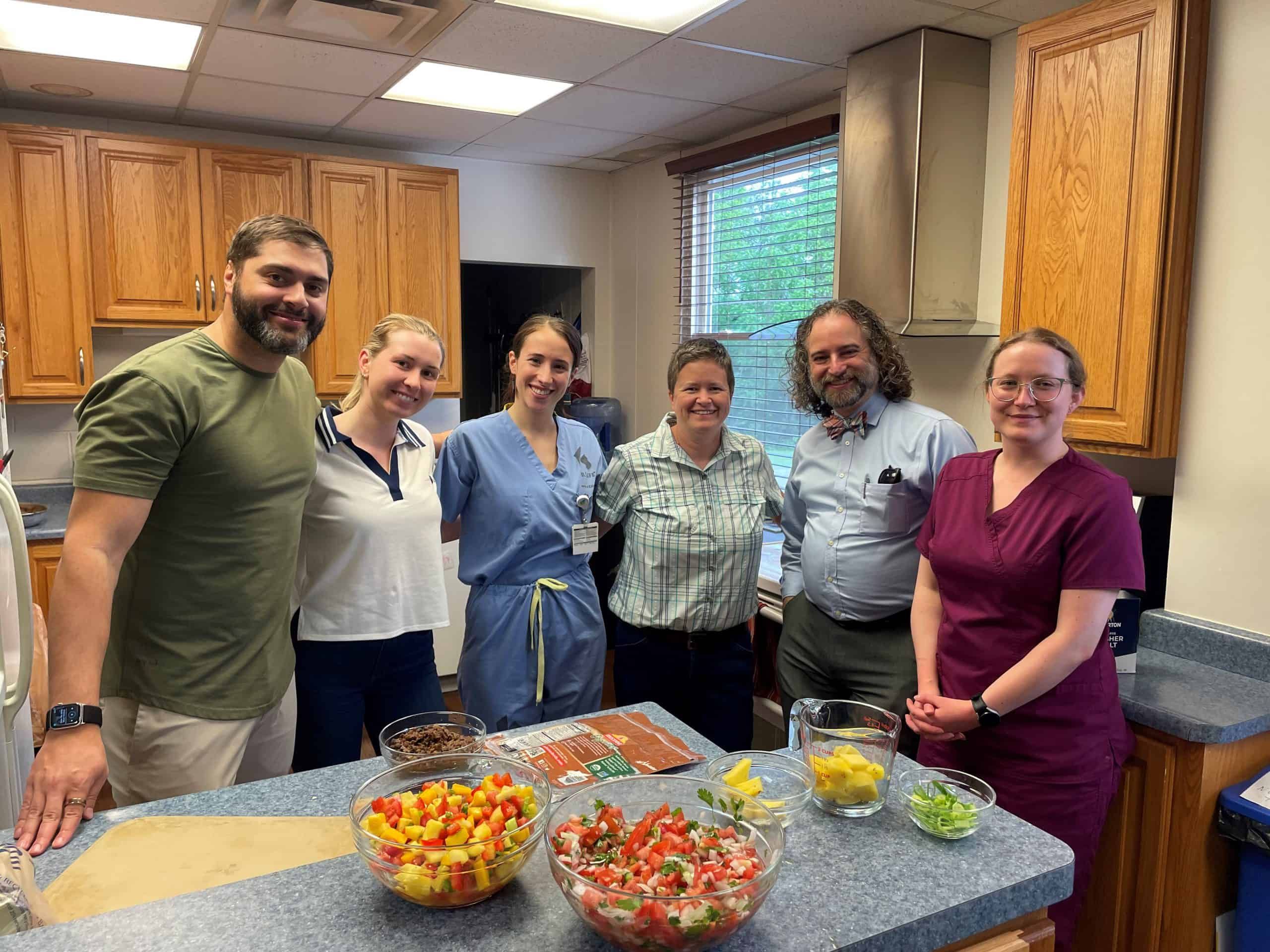 Healthcare team members preparing colorful fresh vegetables and ingredients in kitchen setting