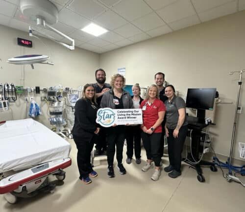 Healthcare team celebrates Living the Mission Award in hospital emergency room
