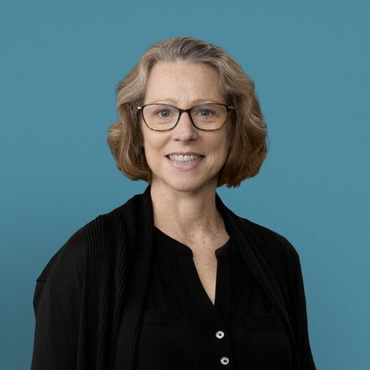 Professional headshot of Dr. Melissa E. Hanna wearing glasses and black cardigan