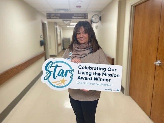 Andrea McKenna posing for picture with Living the Mission Award sign