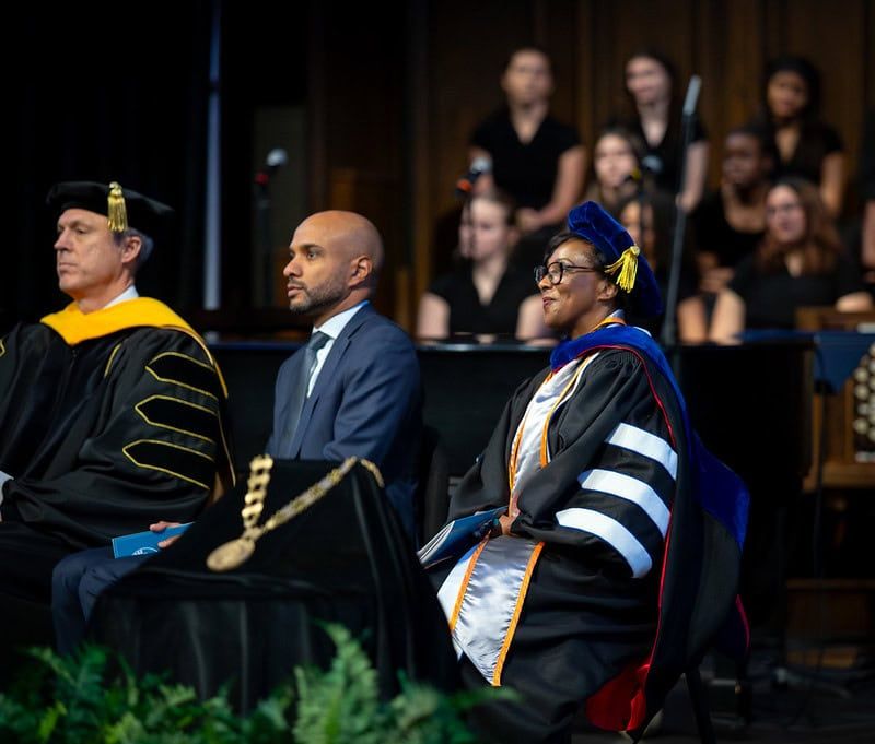 Dr. Mitchell sitting and smiling during the ceremony