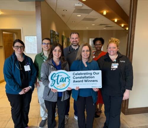 Healthcare team celebrating with Constellation Award Winners sign in hospital lobby