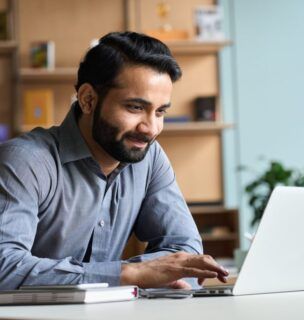 Man sitting and smiling in front of a computer