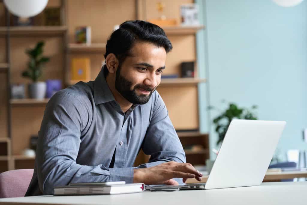 Man sitting and smiling in front of a computer