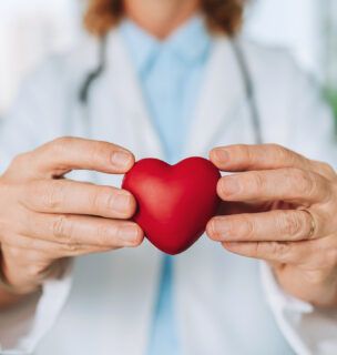 A doctor holding a red heart