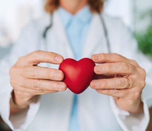 A doctor holding a red heart