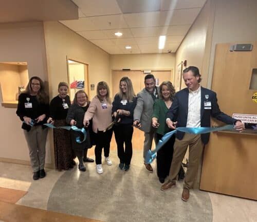 Soin Medical Center team cutting a ribbon in front of the Coats for a Cure closet