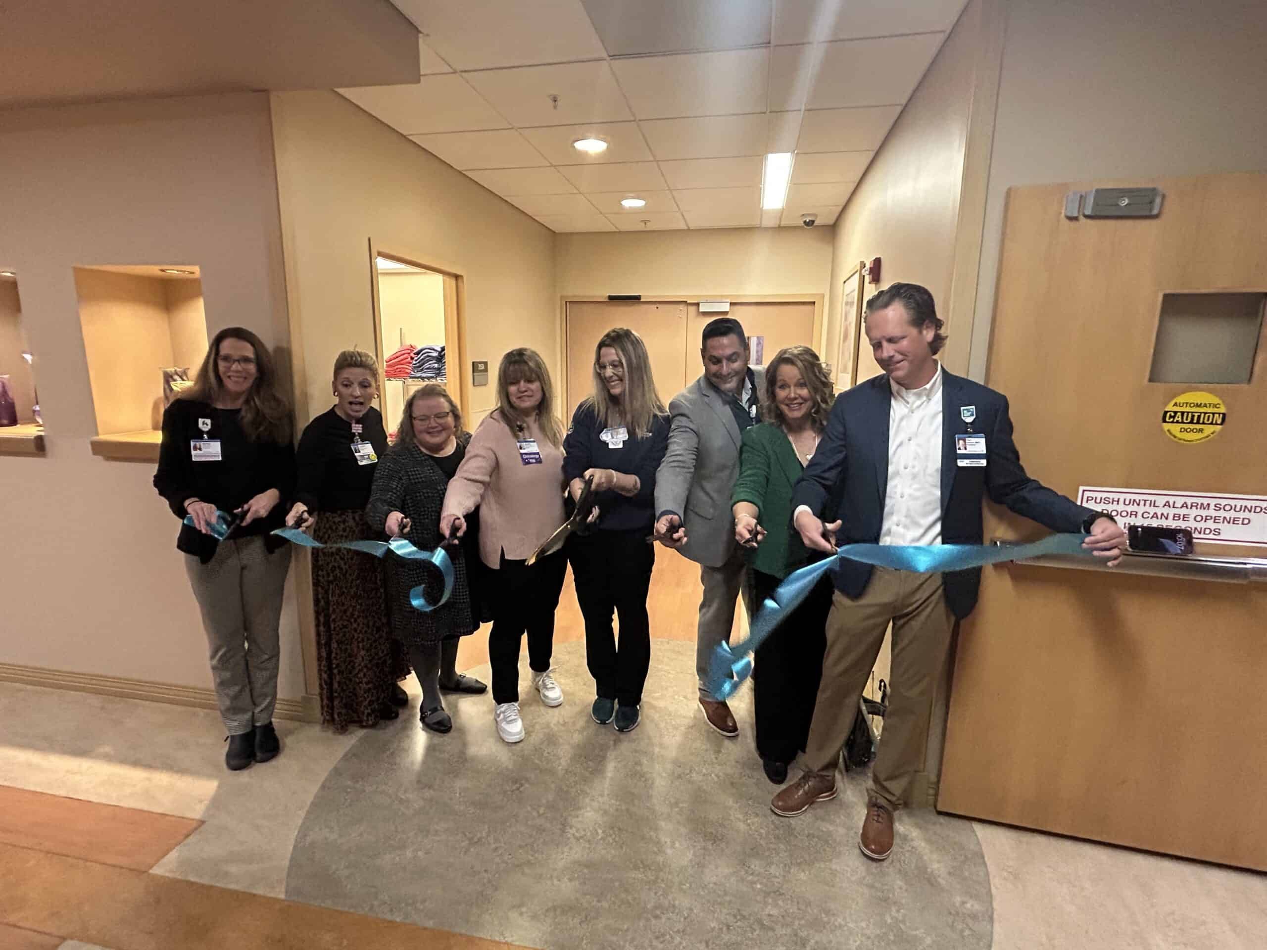Soin Medical Center team cutting a ribbon in front of the Coats for a Cure closet