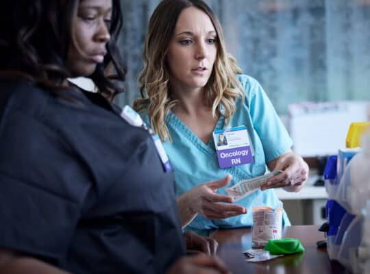 Oncology RN and colleague discussing medication during healthcare team meeting at Kettering Health.