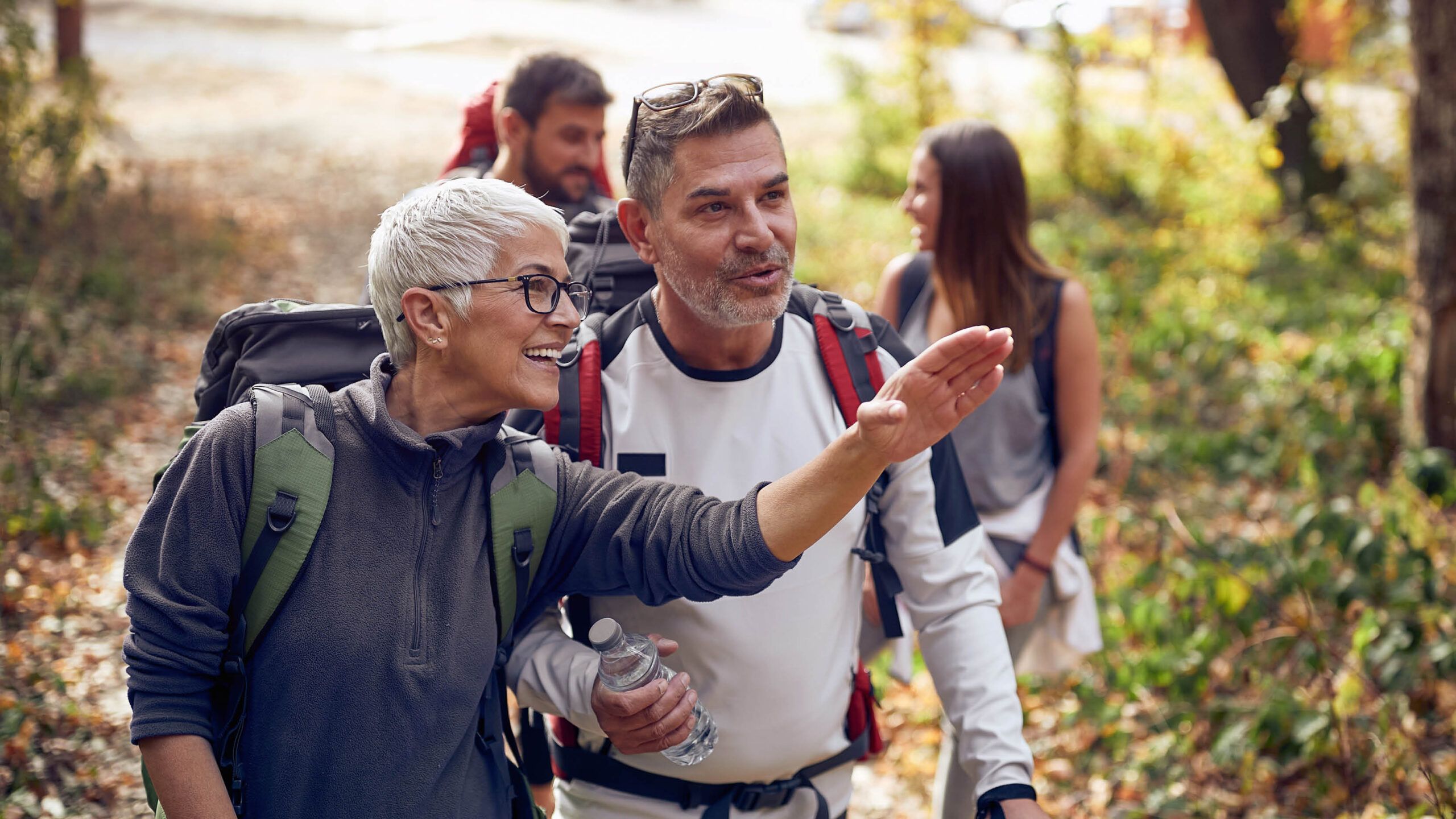 Woman giving direction to a man while hiking