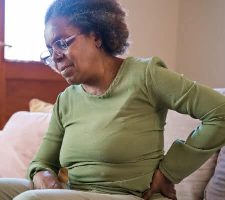 Woman holding her back and hip in pain