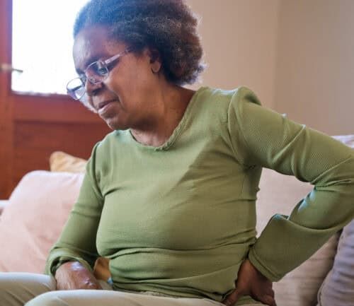 Woman holding her back and hip in pain