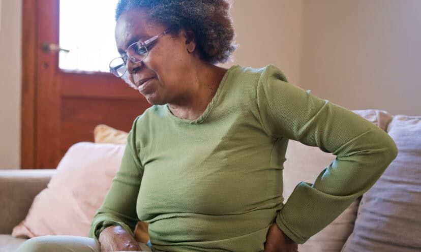 Woman holding her back and hip in pain