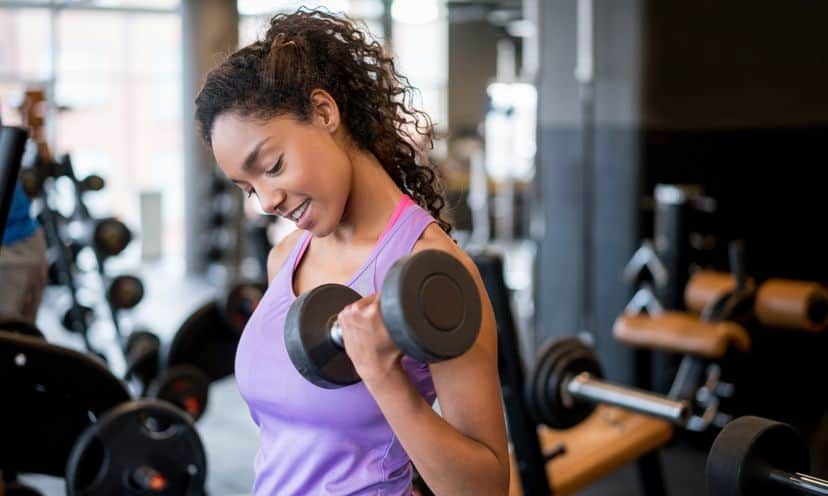 Woman lifting weights and weight training at the gym