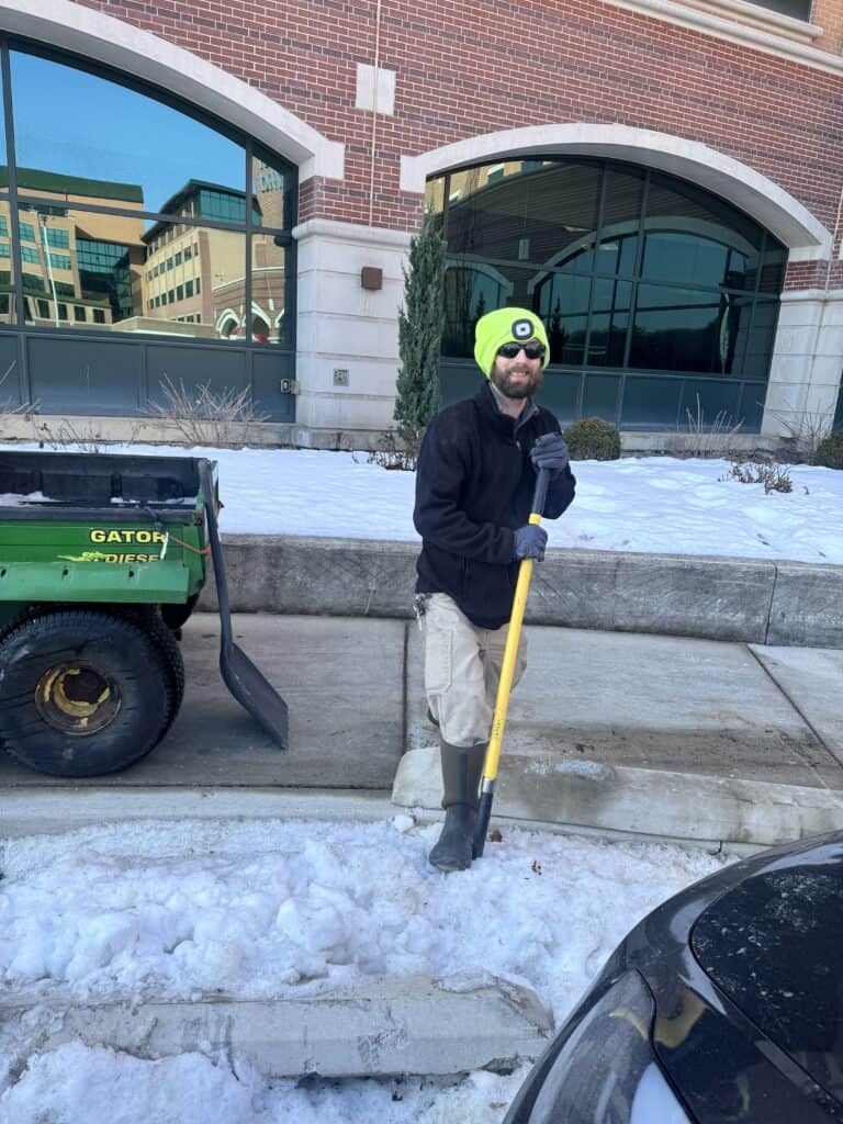 Man standing with a shovel and smiling