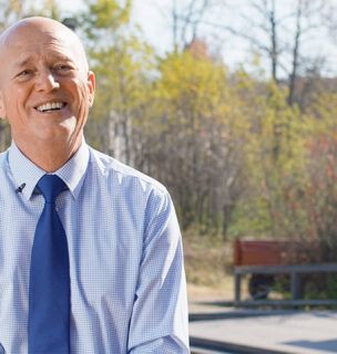 Harold Niehaus smiling outside in front of a park