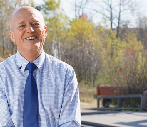 Harold Niehaus smiling outside in front of a park
