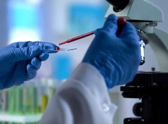 Scientist dripping blood sample for genetics examination, microbiology test