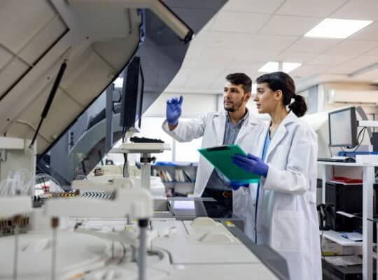 Team of Latin American scientists working at the laboratory processing blood samples - healthcare and medicine concepts