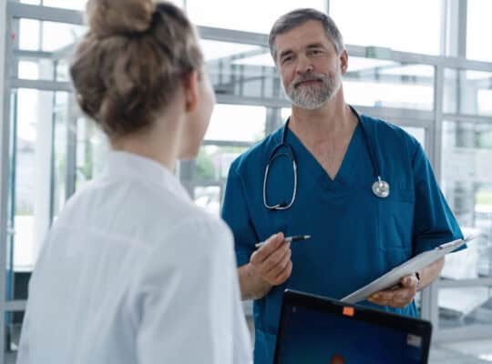 Medical Staff Having Discussion In Modern Hospital Corridor