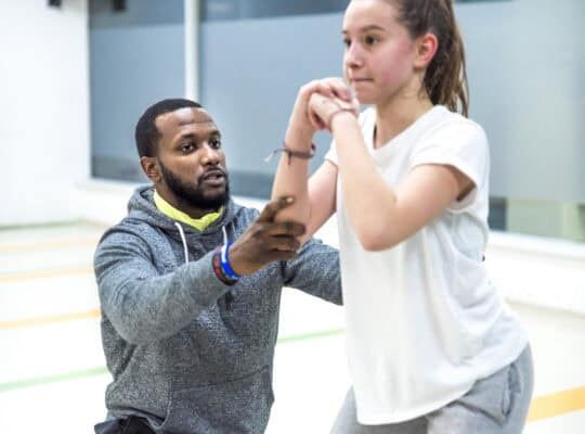 Young man working out with teenage athlete girl.