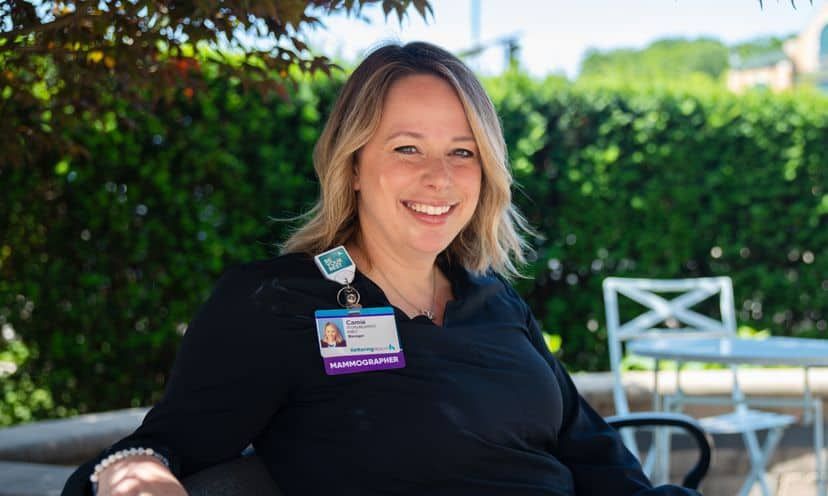 Camie Herrst, mammographer, sitting outside on bench smiling at camera