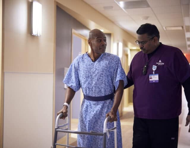 Patient walking with nurse and walker
