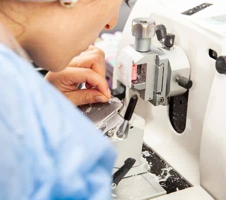 Closeup to the scientist hands working on a rotary microtome to obtain sections from a paraffin-embedded specimen.